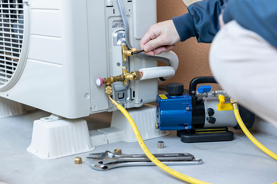 Technician performing AC repair with tools
