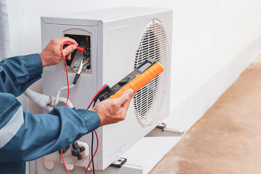 Technician performing AC repair with multimeter