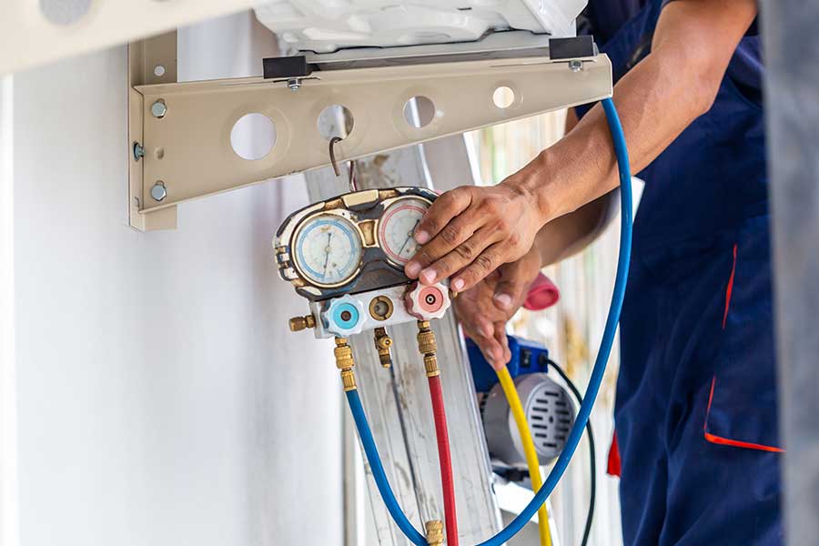 Technician checking AC refrigerant pressure